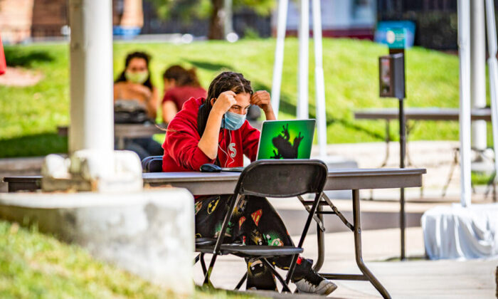 A student does work in the shade at Chapman University in Orange, Calif., on Oct. 14, 2020. (John Fredricks/The Epoch Times)