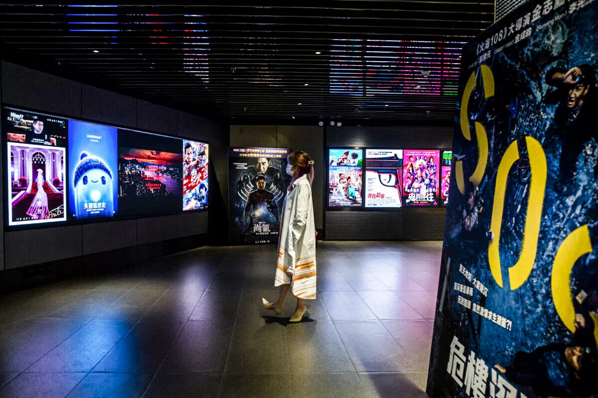 A woman looking at movie advertisements at a cinema in Hong Kong on Sept. 2, 2021. (Isaac Lawrence/AFP via Getty Images)