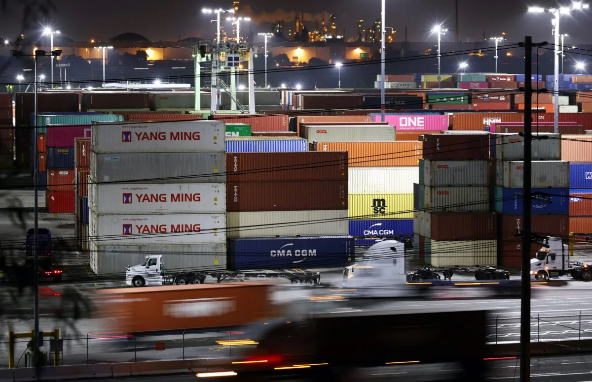 Trucks haul shipping containers at the Port of Los Angeles during nighttime operations in San Pedro, Calif., on Oct. 25, 2021. (Mario Tama/Getty Images)