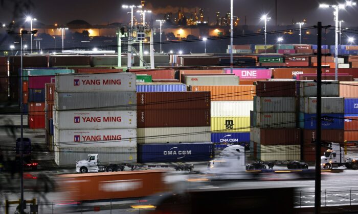 Trucks haul shipping containers astatine  the Port of Los Angeles during nighttime operations successful  San Pedro, Calif., connected  Oct. 25, 2021. (Mario Tama/Getty Images)