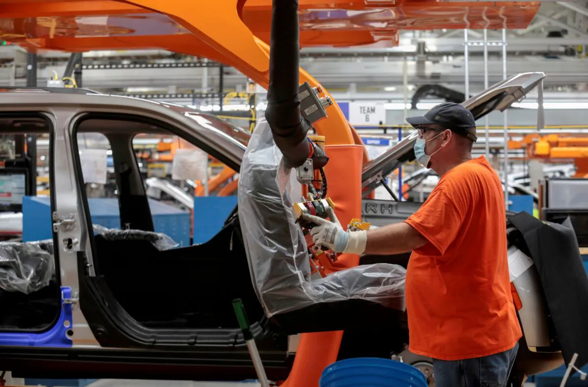 A Stellantis assembly worker prepares to install seats in a 2021 Jeep Grand Cherokee L frame on the assembly line at the Detroit Assembly Complex - Mack Plant in Detroit, Mich., on June 10, 2021. (Rebecca Cook/Reuters)