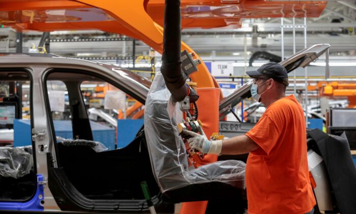 A Stellantis assembly worker prepares to install seats in a 2021 Jeep Grand Cherokee L frame on the assembly line at the Detroit Assembly Complex - Mack Plant in Detroit, Mich., on June 10, 2021. (Rebecca Cook/Reuters)
