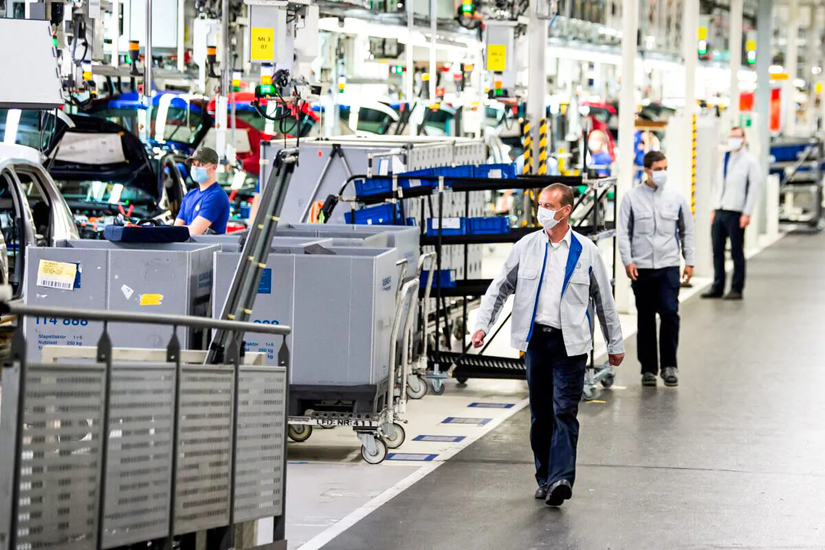 Staff wear protective masks at the Volkswagen assembly line in Wolfsburg, Germany on April 27, 2020. (Swen Pfoertner/Pool via Reuters)