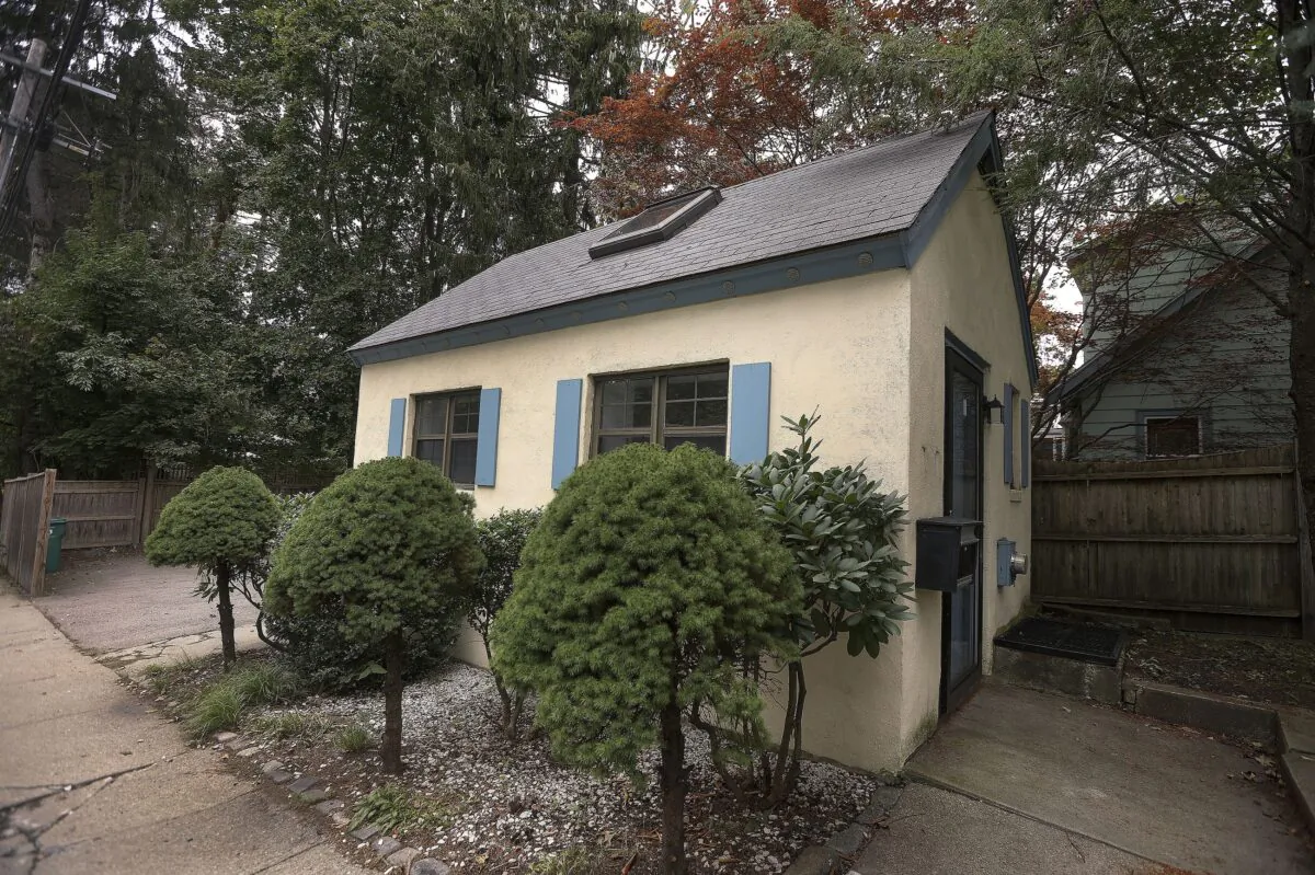 A tiny home in a wealthy Boston suburb stands next to trees and shrubs, in Newton, Mass, on Sept. 30, 2021. (Barry Chin/The Boston Globe via AP)