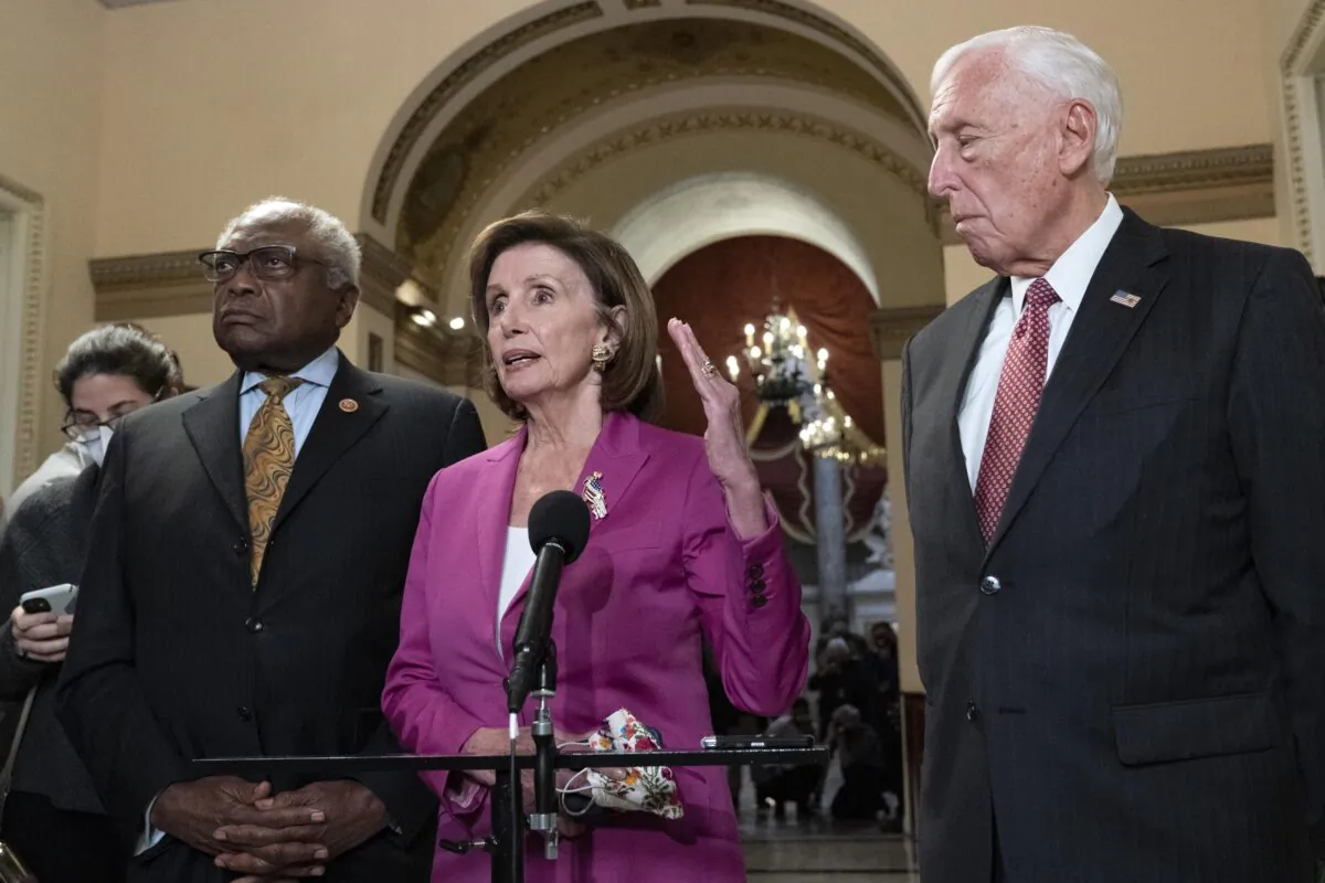 Speaker of the House Nancy Pelosi (D-Calif.), accompanied by House Majority Whip James Clyburn, (D-S.C.)(L) and House Majority Leader Steny Hoyer (D-Md.), speaks to reporters at the Capitol in Washington on Nov. 5, 2021. (Jose Luis Magana/AP Photo)