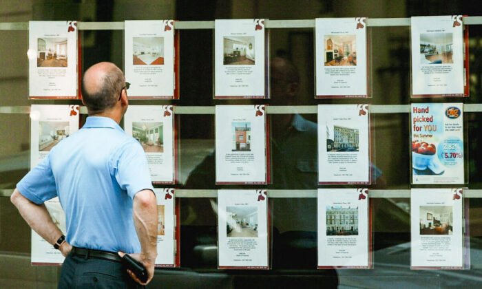 2003 年 7 月 10 日，一名男子在伦敦的一个房地产经纪人窗口查看待售房产。（Scott Barbour/Getty Images）