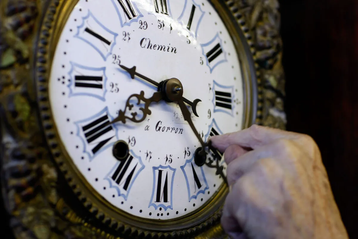 Howie Brown adjusts the time on a clock back one hour for the end of day light savings time at Brown's Old Time Clock Shop in Plantation, Fla., on Nov. 2, 2007. (Joe Raedle/Getty Images)