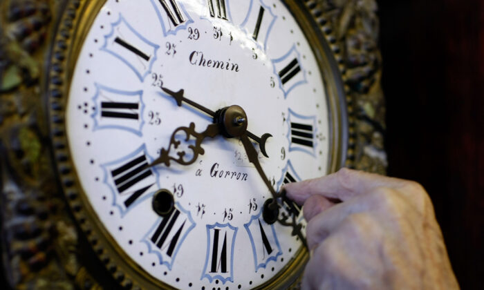 Howie Brown adjusts the time on a clock back one hour for the end of day light savings time at Brown's Old Time Clock Shop in Plantation, Fla., on Nov. 2, 2007. (Joe Raedle/Getty Images)