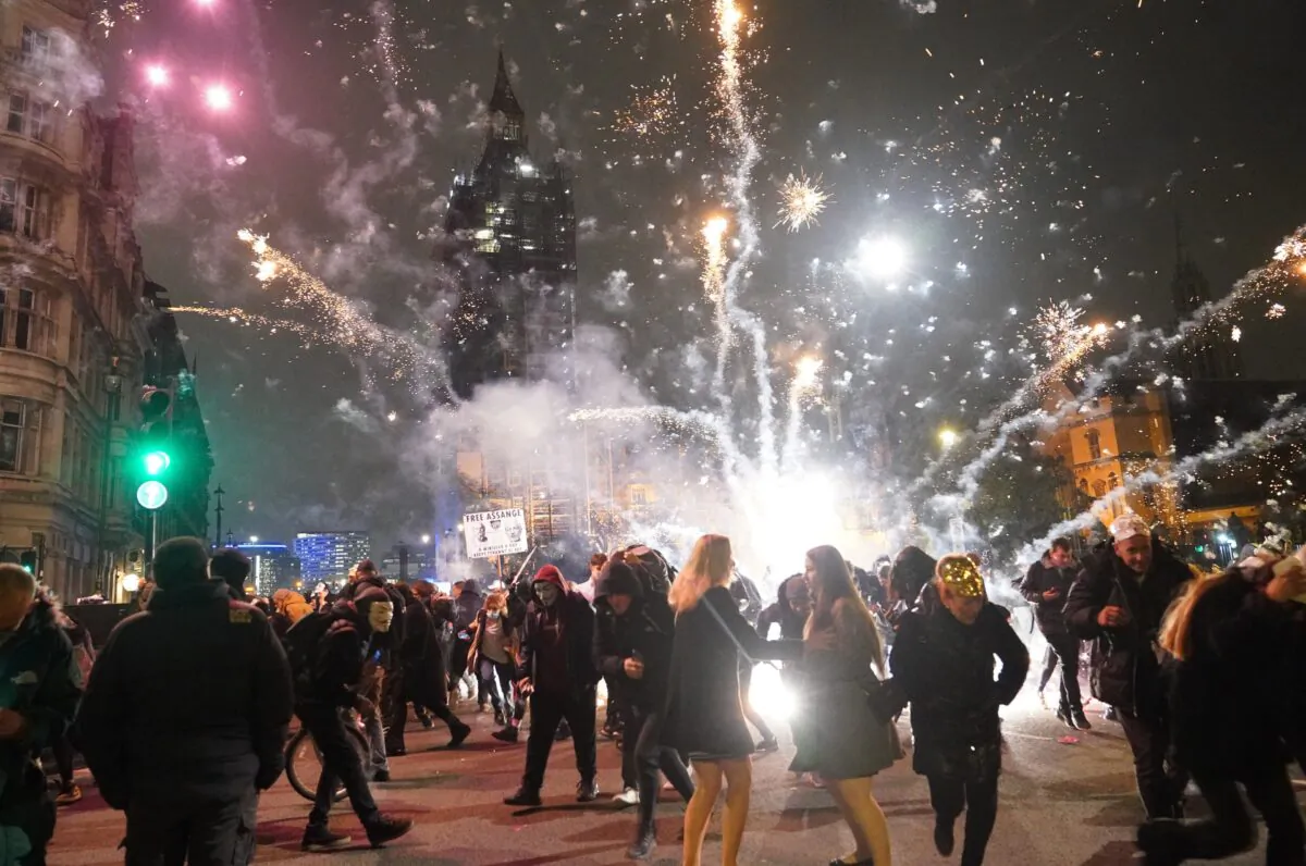 Fireworks are let off as people take part in the Million Mask March in Parliament Square, London, on Nov. 5, 2021. (PA)