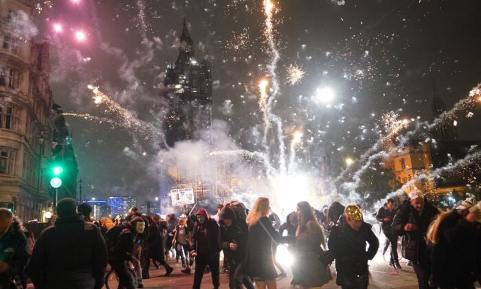 Fireworks are let off as people take part in the Million Mask March in Parliament Square, London, on Nov. 5, 2021. (PA)