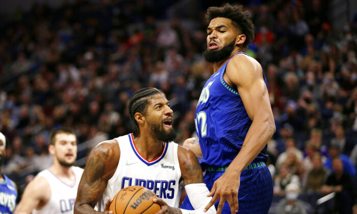 Los Angeles Clippers guard Paul George (L) drives on Minnesota Timberwolves center Karl-Anthony Towns during the first half of an NBA basketball game in Minneapolis, Minn., on Nov. 5, 2021. (Andy Clayton-King/AP Photo)