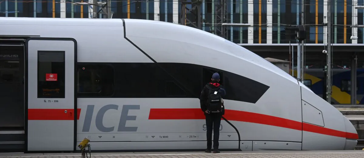 An employee of German railway operator Deutsche Bahn (DB) stands next to an ICE high speed train at the main railway station in Munich, southern Germany, on Aug. 23, 2021. (Christof Stache/AFP via Getty Images)