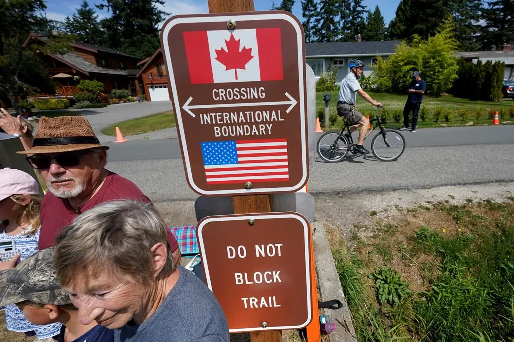 Virus Outbreak US Canada
A family visits across the U.S.-Canada border at the Peace Arch Historical State Park as a cyclist rides past on the Canadian side, Aug. 9, 2021, in Blaine, Wash. Canada lifted its prohibition on Americans crossing the border to shop, vacation, or visit but America kept similar restrictions in place. (AP Photo/Elaine Thompson)