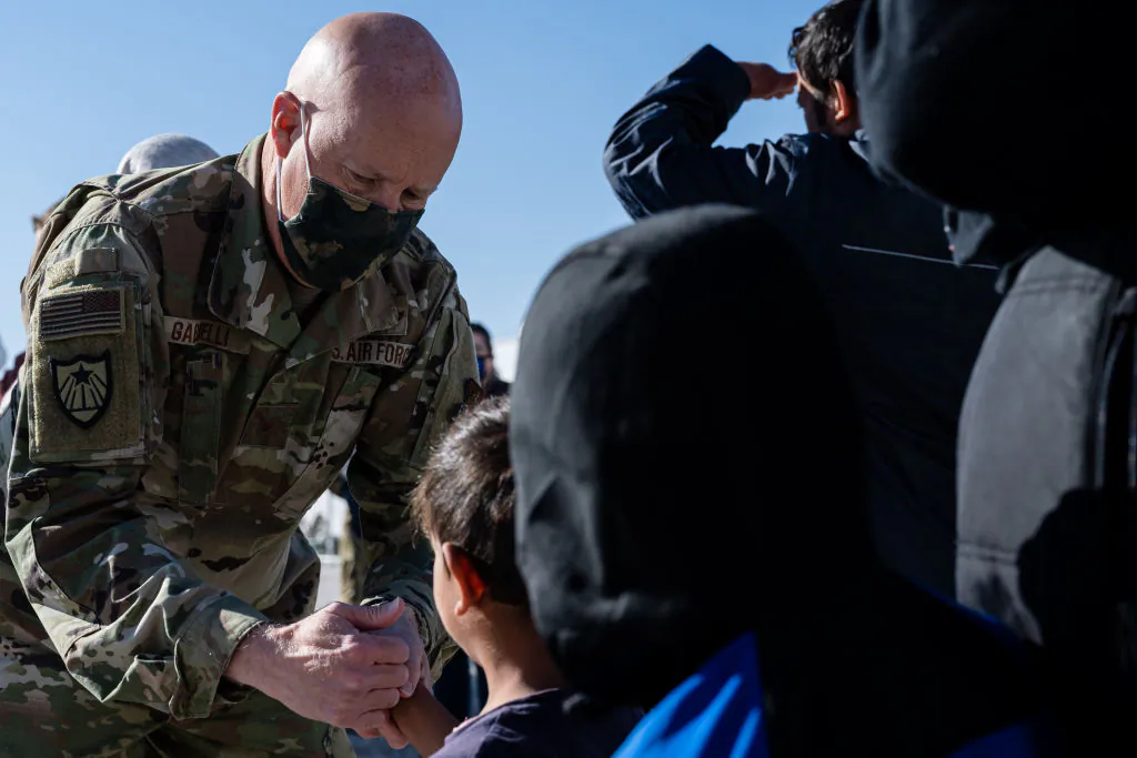 Brig. Gen. Dan Gabrielli greets a young Afghan boy in an Afghan refugee camp in Holloman Air Force Base, New Mexico, on Nov. 4, 2021. (Jon Cherry/Getty Images)