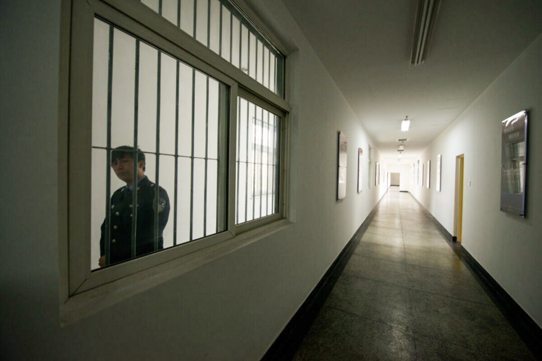 A guard looks through the window of a hallway inside the No.1 Detention Center during a government guided tour in Beijing on Oct. 25, 2012. (Ed Jones/AFP via Getty Images)