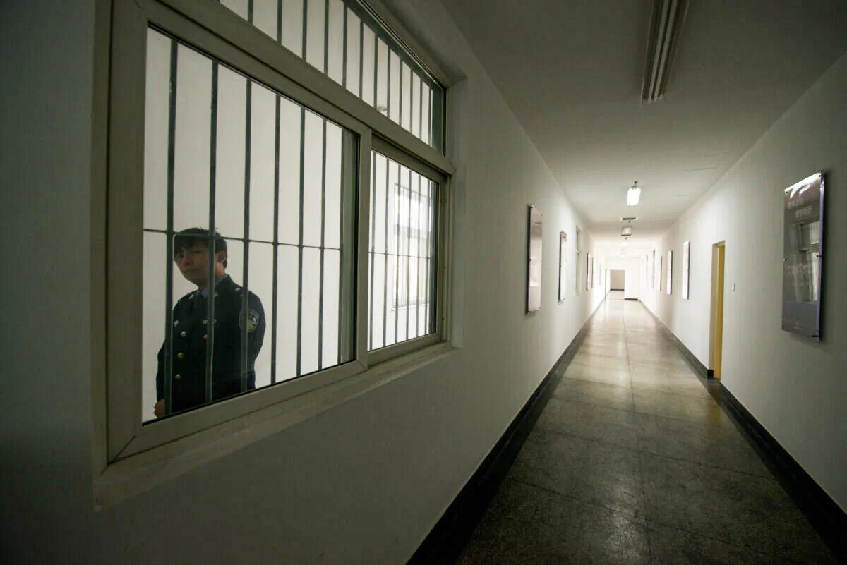 A guard looks through the window of a hallway inside the No.1 Detention Center during a government guided tour in Beijing on October 25, 2012. The rare visit to the facility, which has capacity for 1,000 inmates, was opened to the foreign media as Beijing prepares for the 18th Congress of the Communist Party of China. AFP PHOTO / Ed Jones (Photo credit should read Ed Jones/AFP via Getty Images)
