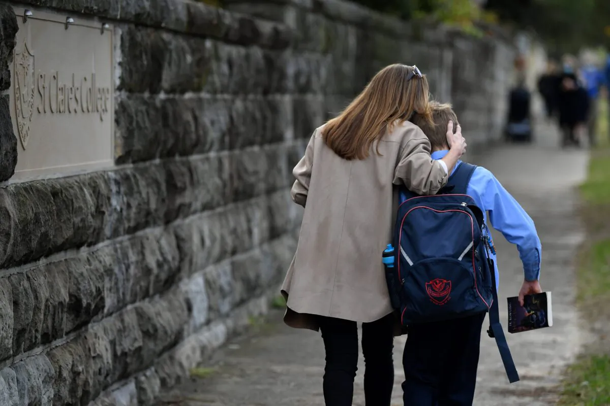 Parents collect children at St Charle's Primary School at Waverley in Sydney, Australia, June 22, 2021.(AAP Image/Joel Carrett)
