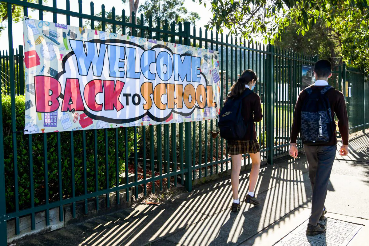 A "Welcome Back to School" banner hangs on the fence as students in years 2 to 11 return to school at Fairvale High School in Sydney, Australia, Oct. 25, 2021. (AAP Image/Bianca De Marchi) 