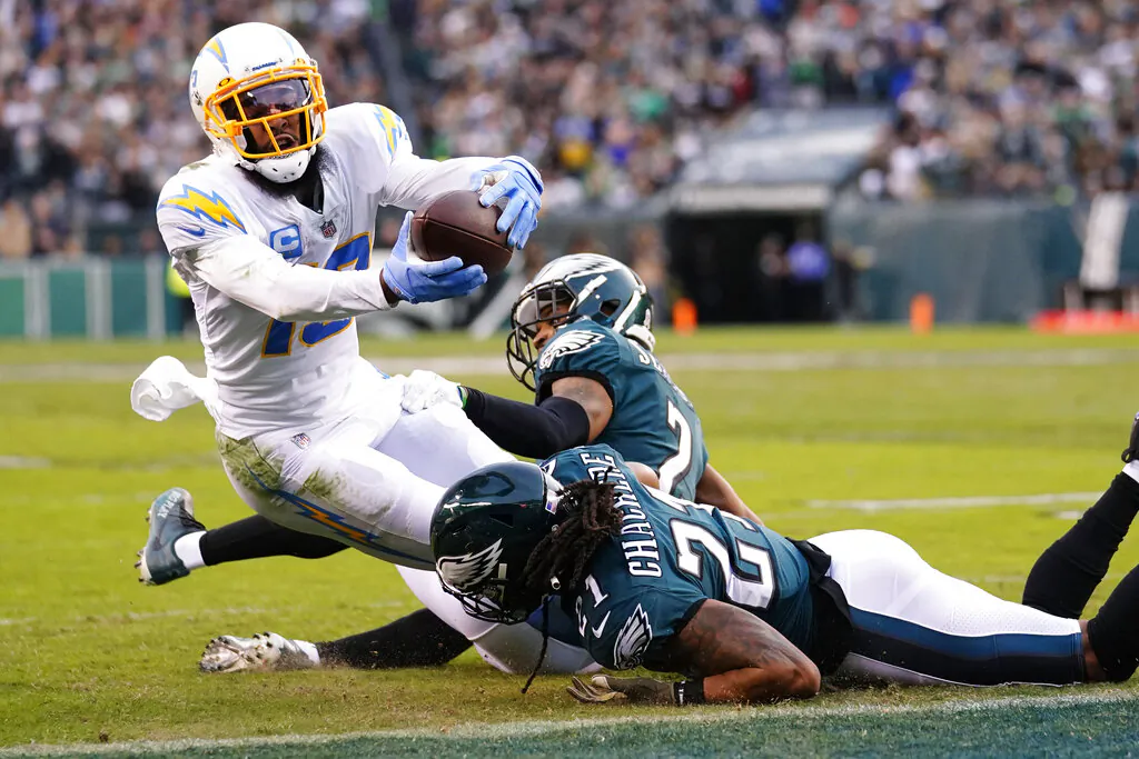 Los Angeles Chargers wide receiver Keenan Allen (13) is brought down with the ball by Philadelphia Eagles defensive back Andre Chachere (21) and Eagles cornerback Darius Slay (2) during the first half of an NFL football game in Philadelphia, on Nov. 7, 2021. (Matt Rourke/AP Photo)