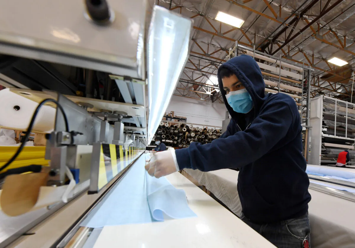 An employee at Polar Shades, a family-owned business that manufactures interior and exterior window shades, makes surgical masks to help health care workers and first responders during the pandemic in Las Vegas, Nevada, on April 14, 2020. (Ethan Miller/Getty Images)