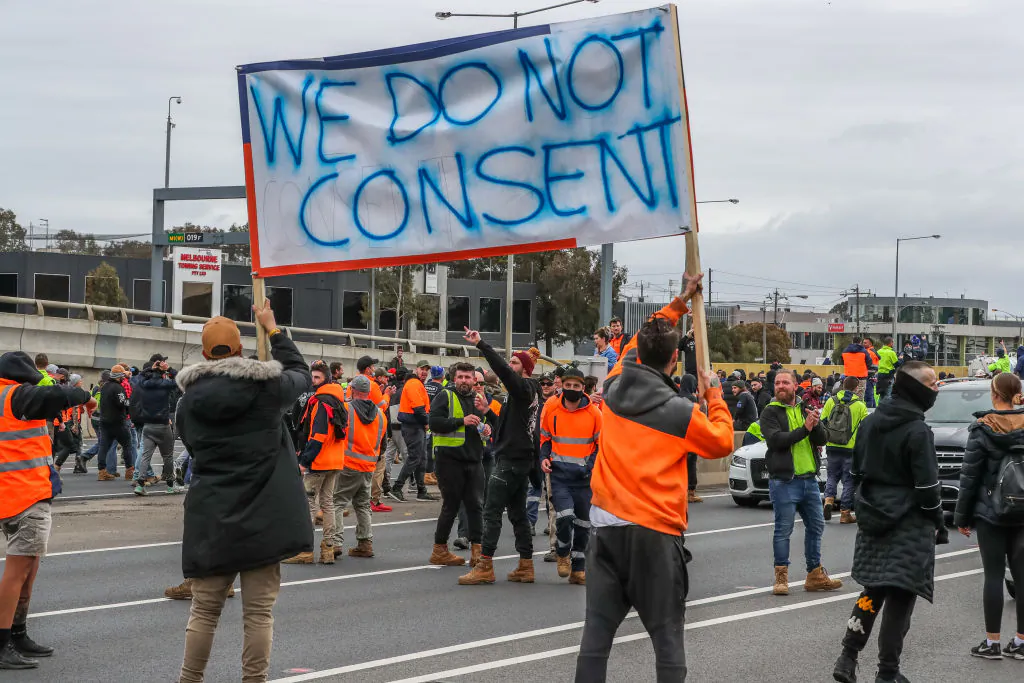 Protestors are seen holding placards as they walk towards Westgate Bridge as thousands march through Melbourne after State Government announces construction shutdown in Melbourne, Australia, on Sept. 21, 2021. (Asanka Ratnayake/Getty Images)
