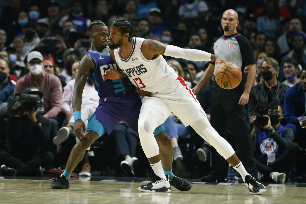 Los Angeles Clippers forward Paul George (13) dribbles against Charlotte Hornets guard Terry Rozier (3) during the first half of an NBA basketball game in Los Angeles on Nov. 7, 2021. (AP Photo/Ringo H.W. Chiu)