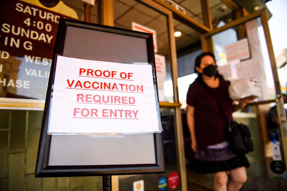 A sign stating proof of a Covid-19 vaccination is required is displayed outside of Langer's Deli in Los Angeles on August 7, 2021. (Patrick T. Fallon/AFP via Getty Images)