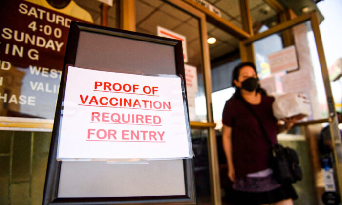 A sign stating proof of a Covid-19 vaccination is required is displayed outside of Langer's Deli in Los Angeles on August 7, 2021. (Patrick T. Fallon/AFP via Getty Images)