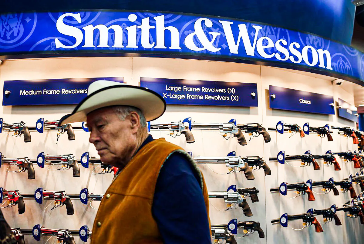 An attendee walks through the Smith & Wesson booth during the 2013 NRA Annual Meeting and Exhibits at the George R. Brown Convention Center in Houston on May 3, 2013. New York Public Advocate Bill de Blasio announced on July 22 that eight hedge funds and money managers have divested gun holdings valued at $150 million. (Justin Sullivan/Getty Images)