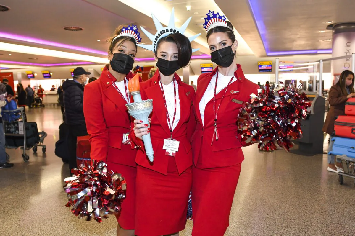 Virgin Atlantic cabin crew staff pose for photos ahead of the departure of Virgin Atlantic flight VS3, at Terminal 3 of London Heathrow Airport, on Nov. 8, 2021. (PA)