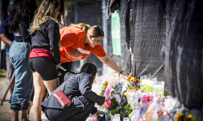 Stacey Sarmiento places flowers at a memorial in Houston on Sunday, November 7th, 2021 in memory of her friend Rudy Pena who died in a crush of people at the Astroworld music festival on Friday. (AP Photo/Robert Bumsted)