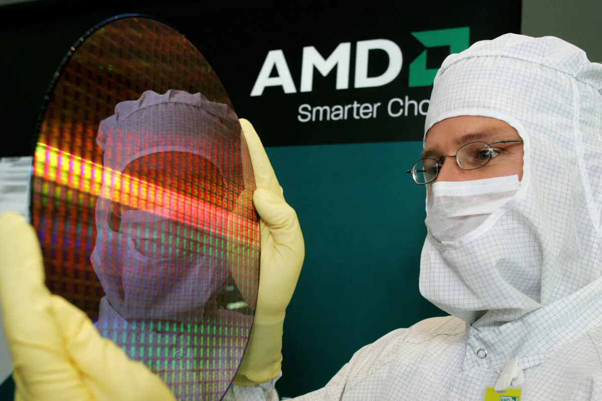 Module Shift Manager Guido Gebert presents a 300-millimeter wafer of Advanced Micro Devices (AMD), the U.S. maker of computer chips in Dresden, eastern Germany, on Oct. 24, 2006. (Norbert Millauer/DDP/AFP via Getty Images)