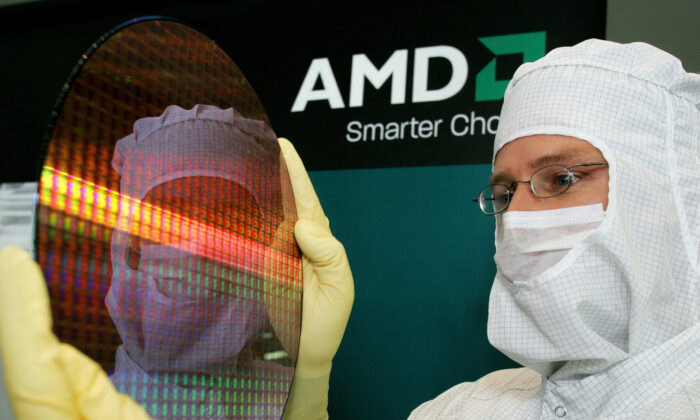 Module Shift Manager Guido Gebert presents a 300-millimeter wafer of Advanced Micro Devices (AMD), the U.S. maker of computer chips in Dresden, eastern Germany, on Oct. 24, 2006. (Norbert Millauer/DDP/AFP via Getty Images)