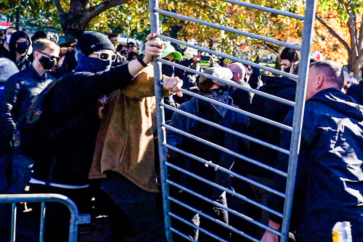 Anti-fascism protesters removed police fences. The two groups had brief clashes.(Learner Liu/The Epoch Times)