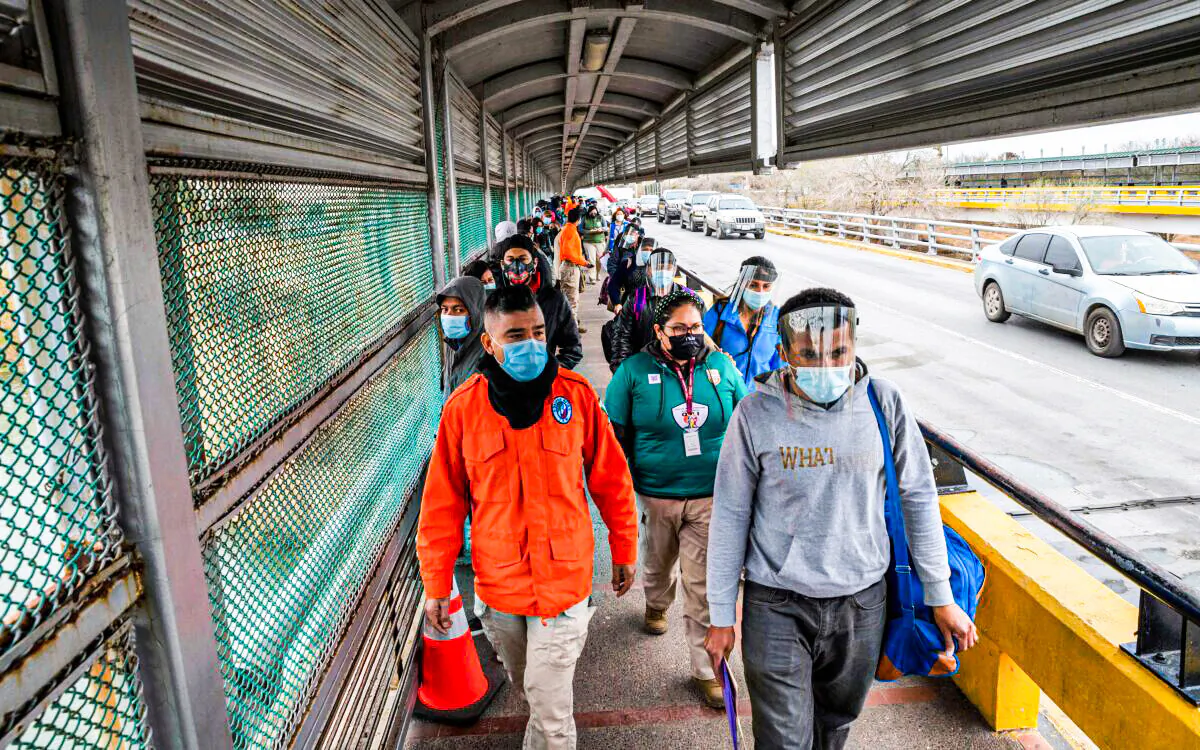 Migrants approach the U.S. border on Gateway International Bridge in Brownsville, Texas, on March 2, 2021. (Sergio Flores/AFP via Getty Images)