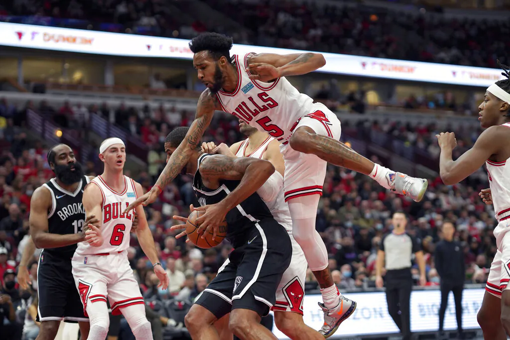Chicago Bulls' Derrick Jones Jr. (5) gets airborne on a head fake by Brooklyn Nets' LaMarcus Aldridge during the first half of an NBA basketball game in Chicago, on Nov. 8, 2021. (Charles Rex Arbogast/AP Photo)