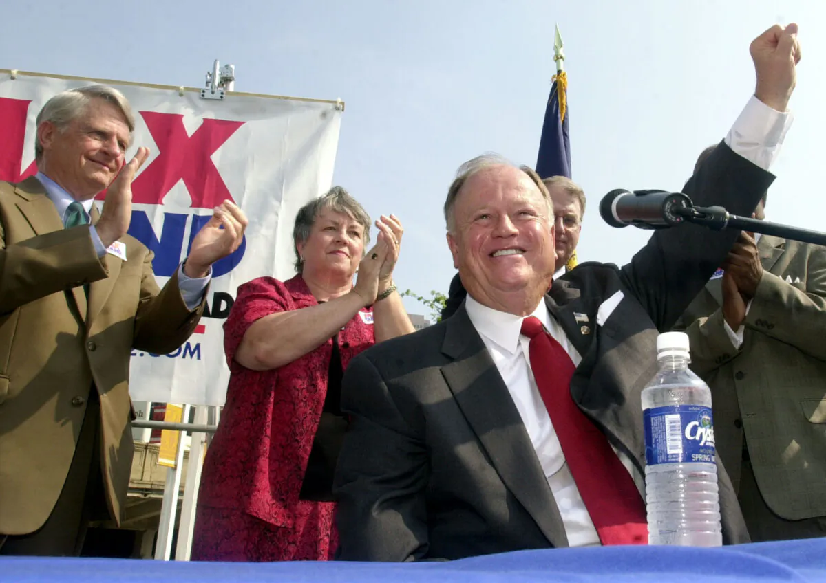 Sen. Max Cleland (D-Ga.), foreground, raises his hand to the crowd at a campaign rally in downtown Atlanta, on Aug. 21, 2002. (Ric Feld/AP Photo)