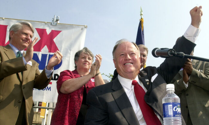 Sen. Max Cleland (D-Ga.), foreground, raises his hand to the crowd at a campaign rally in downtown Atlanta, on Aug. 21, 2002. (Ric Feld/AP Photo)