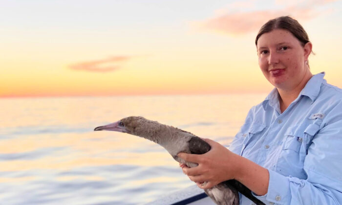 Bianca Keys aboard a research vessel with a Red-footed Booby. (Kaarel Raia)