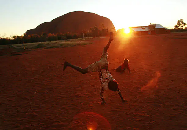 A child plays at sunset in the Aboriginal community of Mutitjulu, in the shadow of Uluru, in the Northern Territory (Jason South/Getty Images)