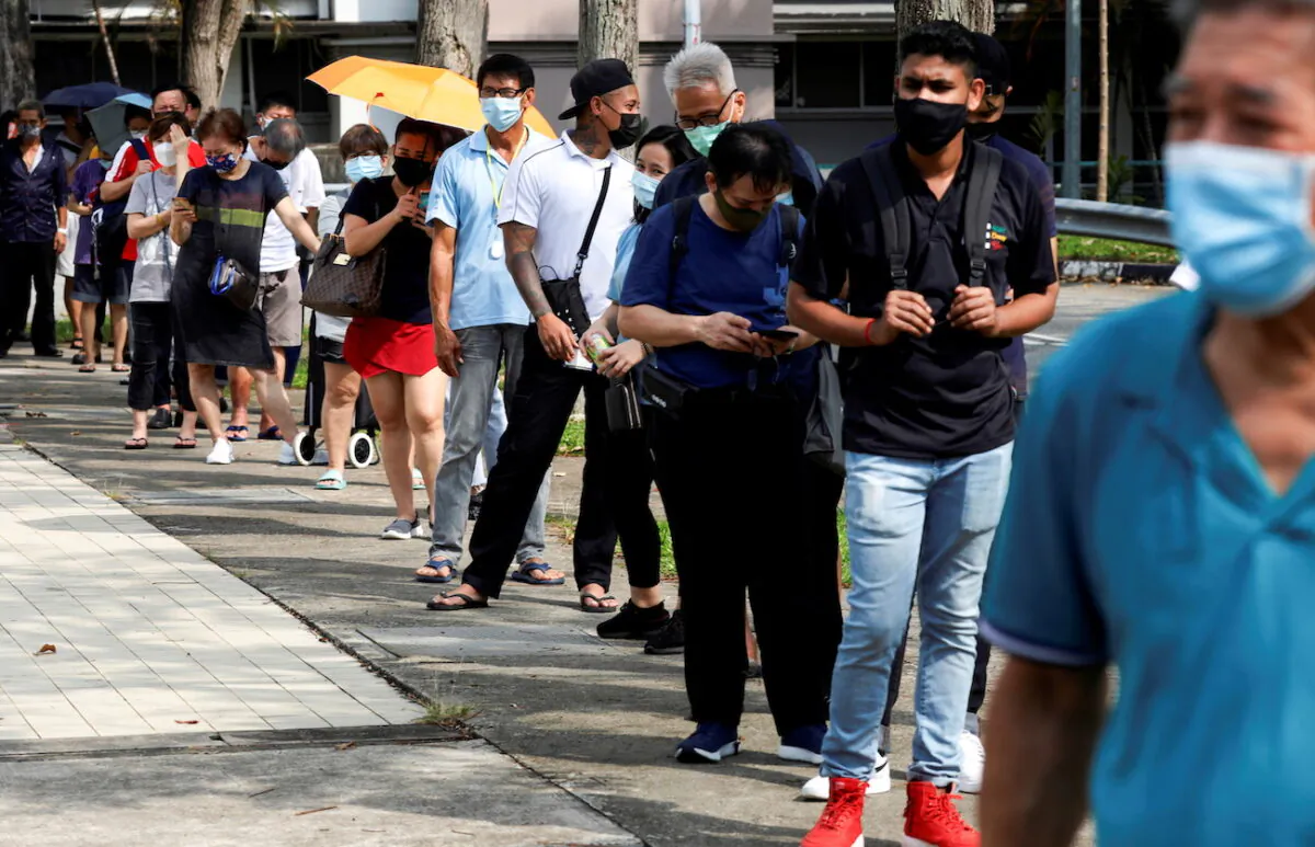 People line up outside a quick test center to take their COVID-19 antigen rapid tests, in Singapore on Sept. 21, 2021. (Edgar Su/Reuters)