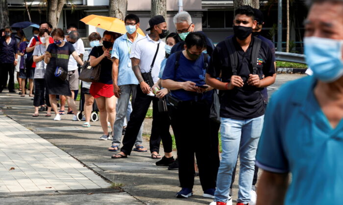 People line up outside a quick test center to take their COVID-19 antigen rapid tests, in Singapore on Sept. 21, 2021. (Edgar Su/Reuters)