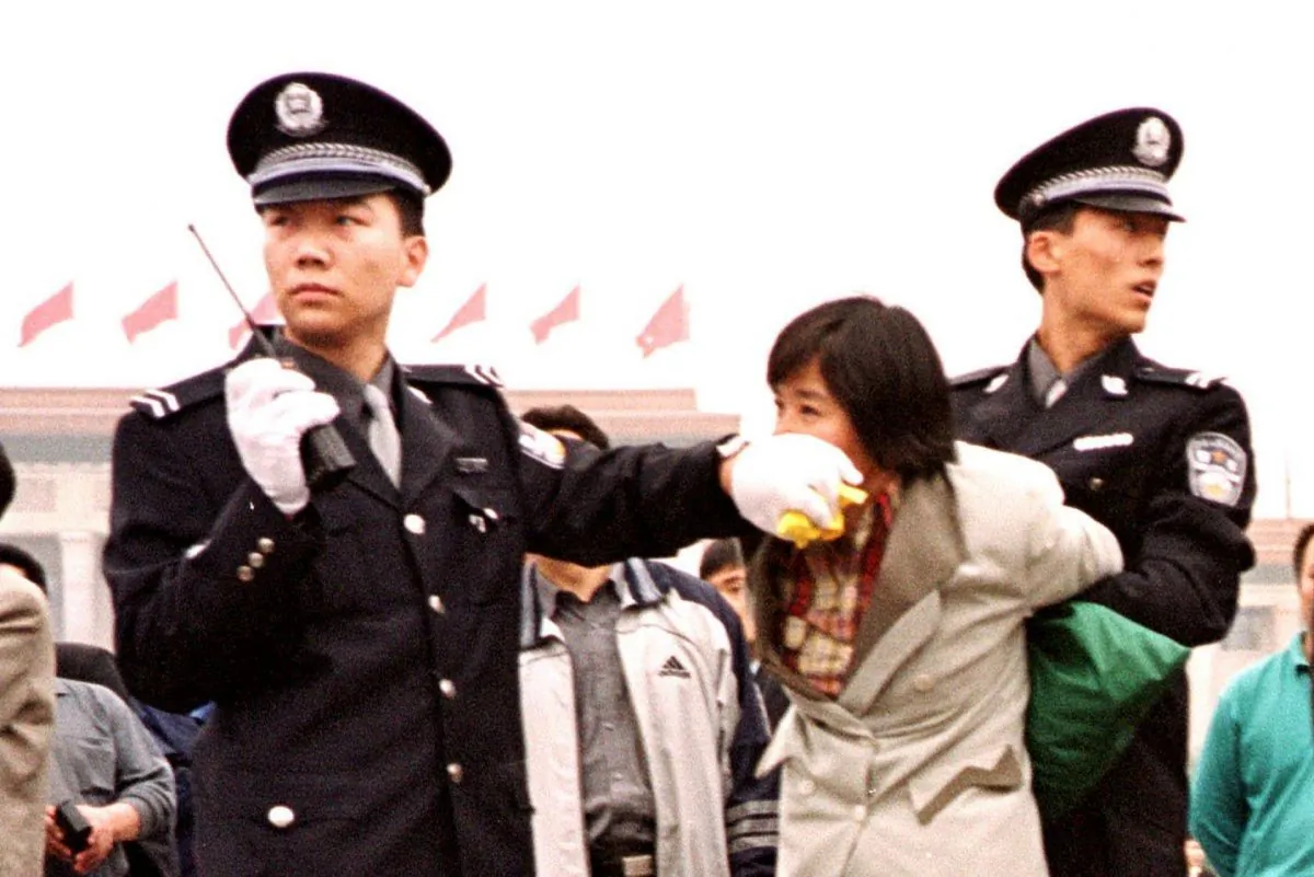 Two Chinese police officers arrest a Falun Gong practitioner at Tiananmen Square in Beijing on Jan. 10, 2000. (Chien-Min Chung/AP Photo)