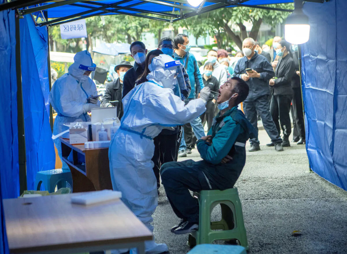 People line up at a makeshift nucleic acid testing site near a residential compound under lockdown in Chengdu, Sichuan Province, China, on Nov. 3, 2021. (cnsphoto via Reuters)