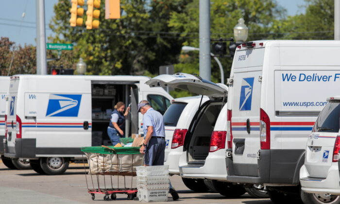 U.S. Postal Service (USPS) workers load mail into delivery trucks outside a post office in Royal Oak, Mich., on Aug. 22, 2020. (Rebecca Cook/Reuters)