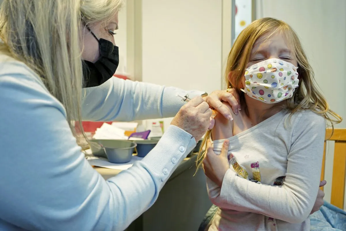 A nurse volunteering at the University of Washington Medical Center gives the first shot of the Pfizer COVID-19 vaccine to a 7-year-old girl in Seattle, Wash., on Nov. 9, 2021. (Ted S. Warren/AP Photo)