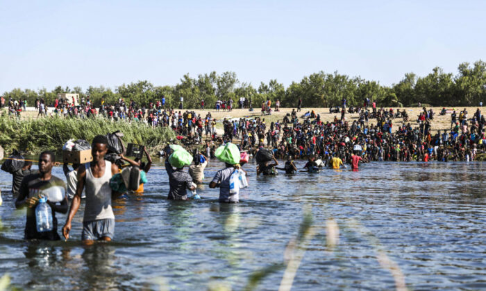 Illegal immigrants cross the Rio Grande between Del Rio, Texas (far side), and Acuña, Mexico, on Sept. 20, 2021. (Charlotte Cuthbertson/The Epoch Times)