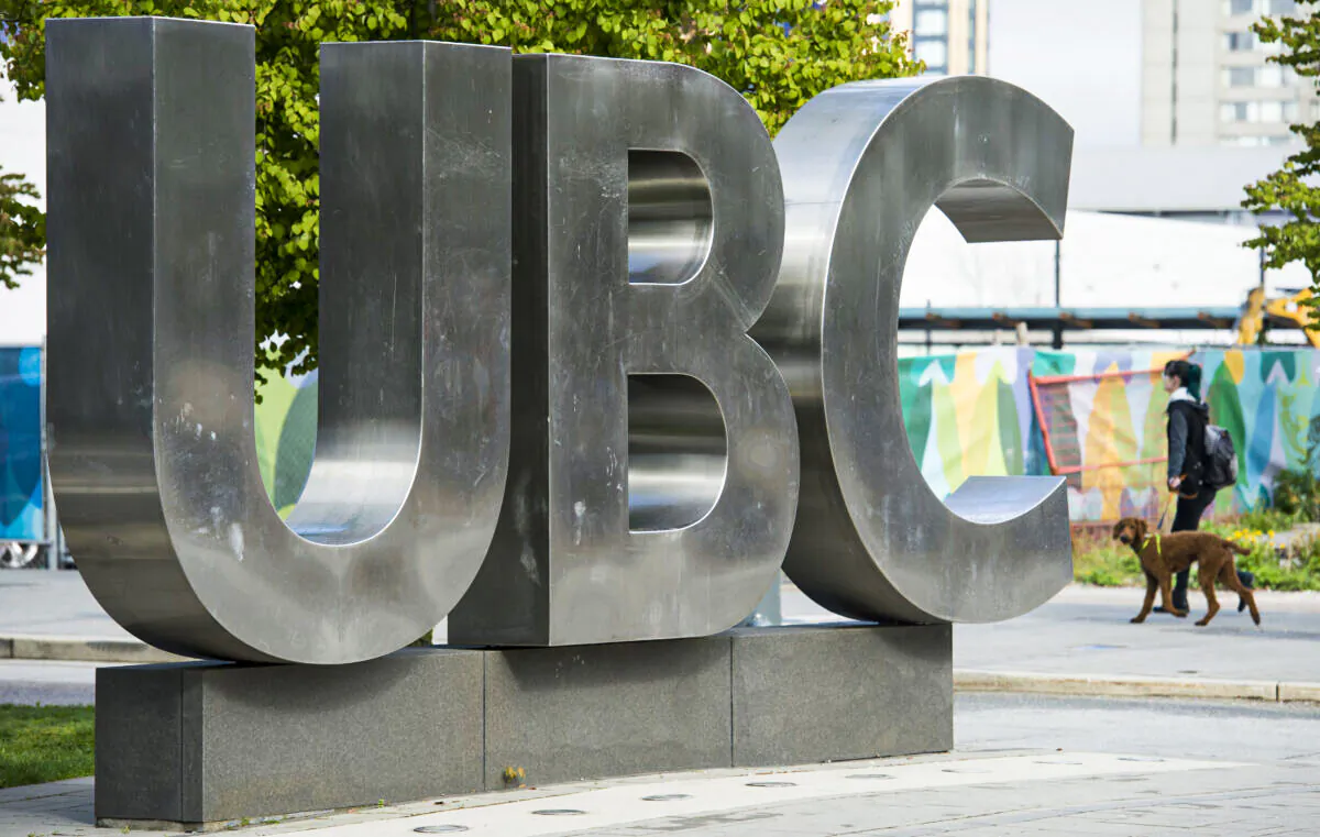 A woman and her dog walks past the UBC sign at the University of British Columbia in Vancouver, Tuesday, Apr 23, 2019.  THE CANADIAN PRESS/Jonathan Hayward