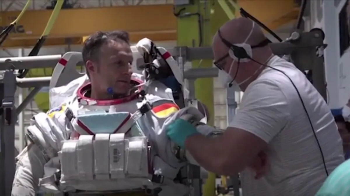German astronaut Matthias Maurer training at Neutral Buoyancy Laboratory, suiting up for Crew 3 training with fellow astronaut Raja Chari, in a still image from video. (ESA/NASA via AP/Screenshot via NTD)