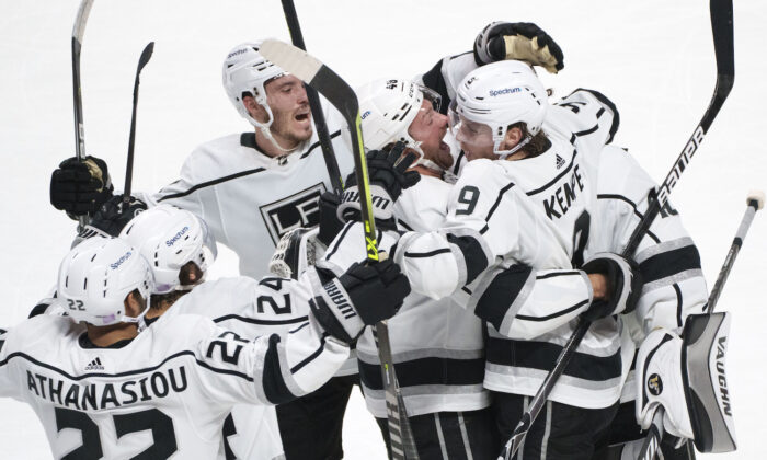Los Angeles Kings' Adrian Kempe (9) celebrates with teammates after scoring the game-winning goal against the Montreal Canadiens during overtime in NHL hockey game in Montreal on Nov. 9, 2021. (Paul Chiasson/ Canadian Press via AP)